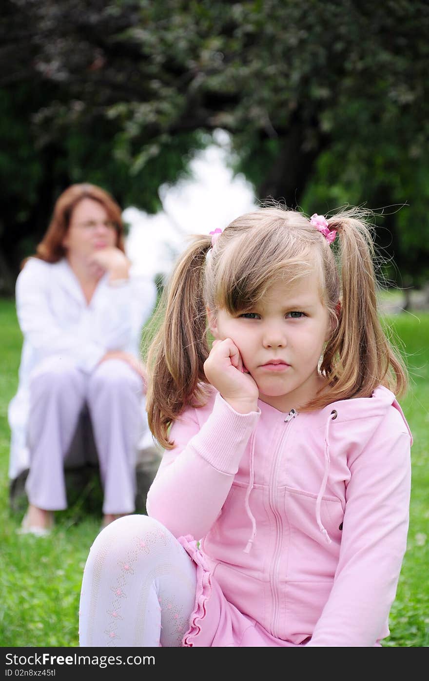 Girl and mother sitting on rocks in nature. Girl and mother sitting on rocks in nature