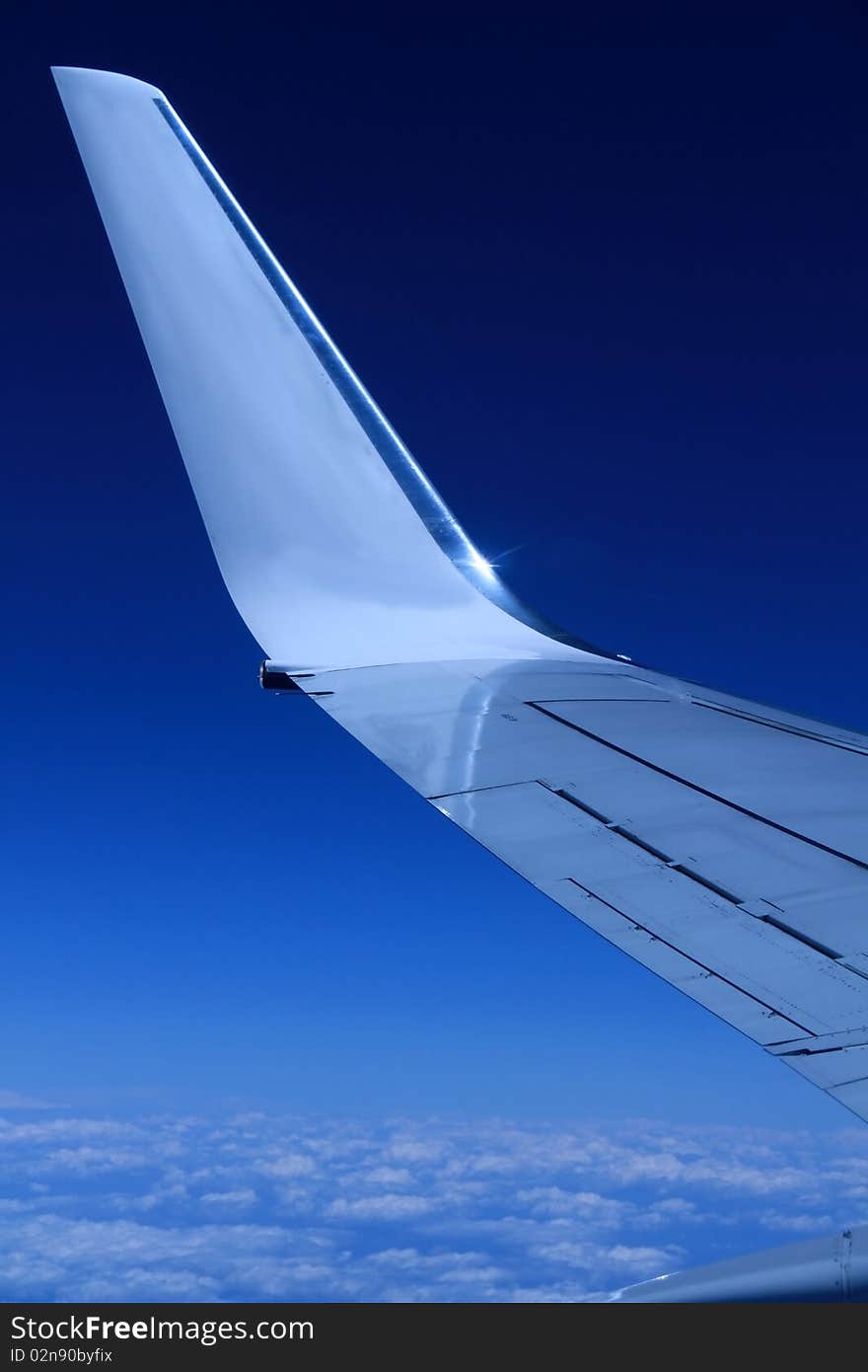 Airplane wing in the sky with blue background stock photo