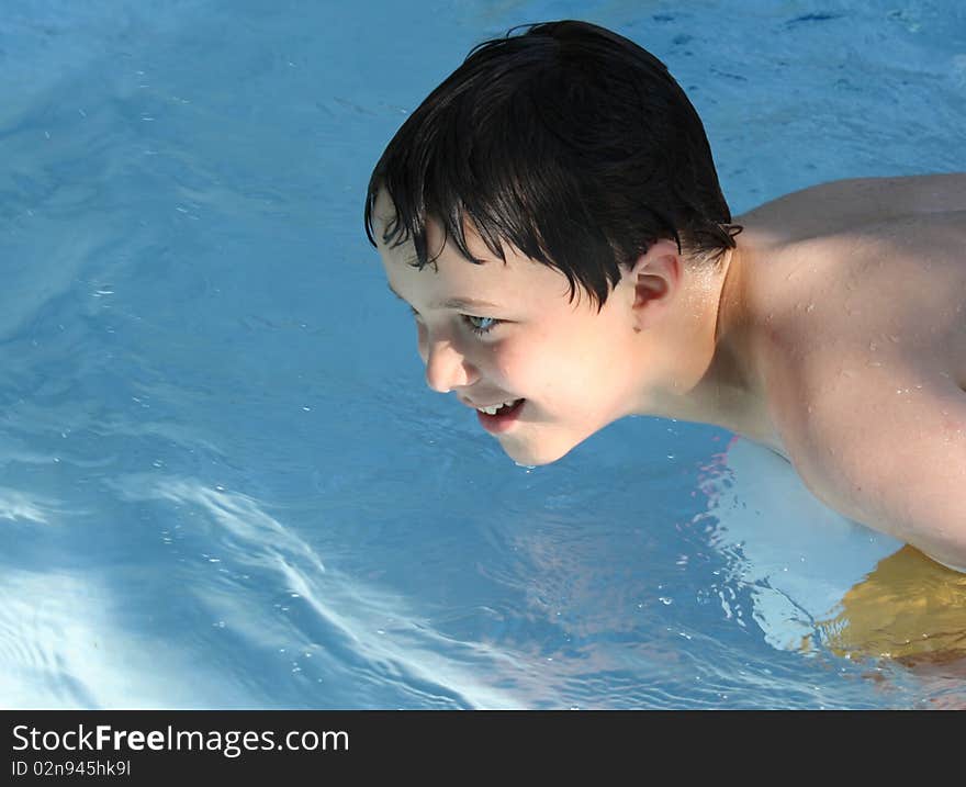 Happy boy on a beach ball in a pool. Happy boy on a beach ball in a pool.