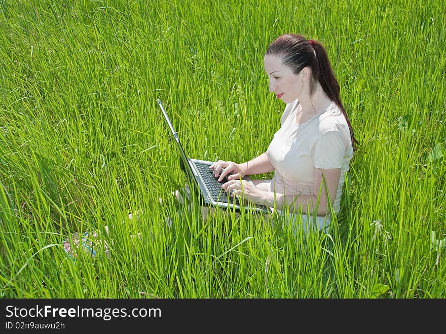 Beautiful girl setting outdoor with laptop summer