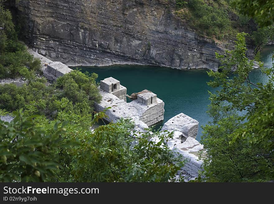 Old dam along the river bed, water depth taking color deep green