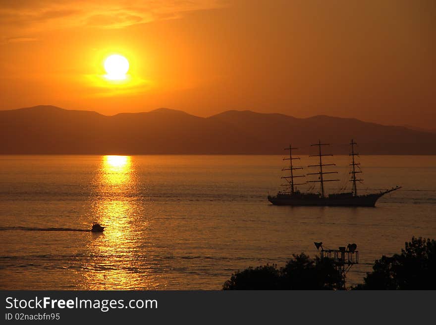 Yacht in gulf, mountains on background, sunset, summer. Yacht in gulf, mountains on background, sunset, summer.