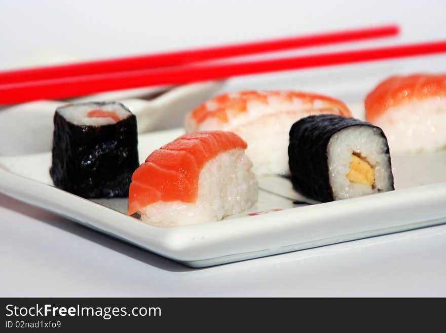 Sushi meal still-life with rice, fish and red chopsticks