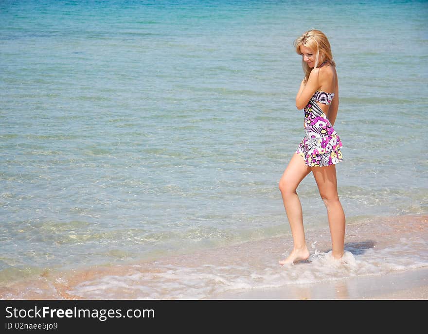 Young smiling girl walking in water