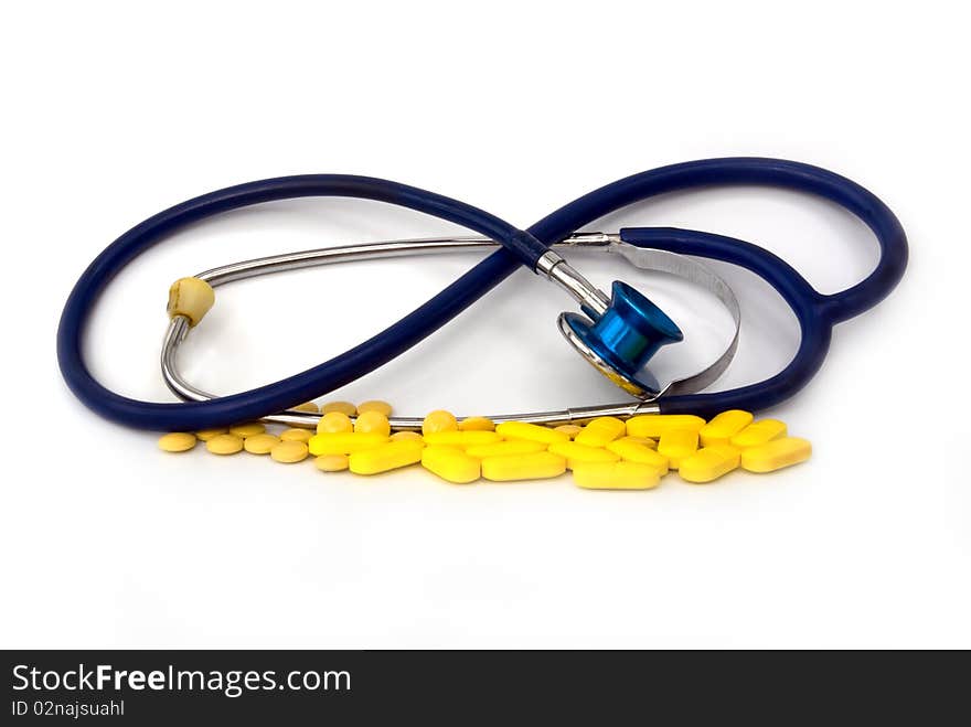 Stethoscope with pill against white background