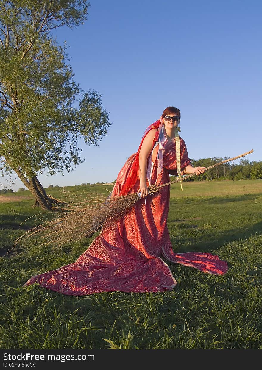 Witch in the open air holding a broom