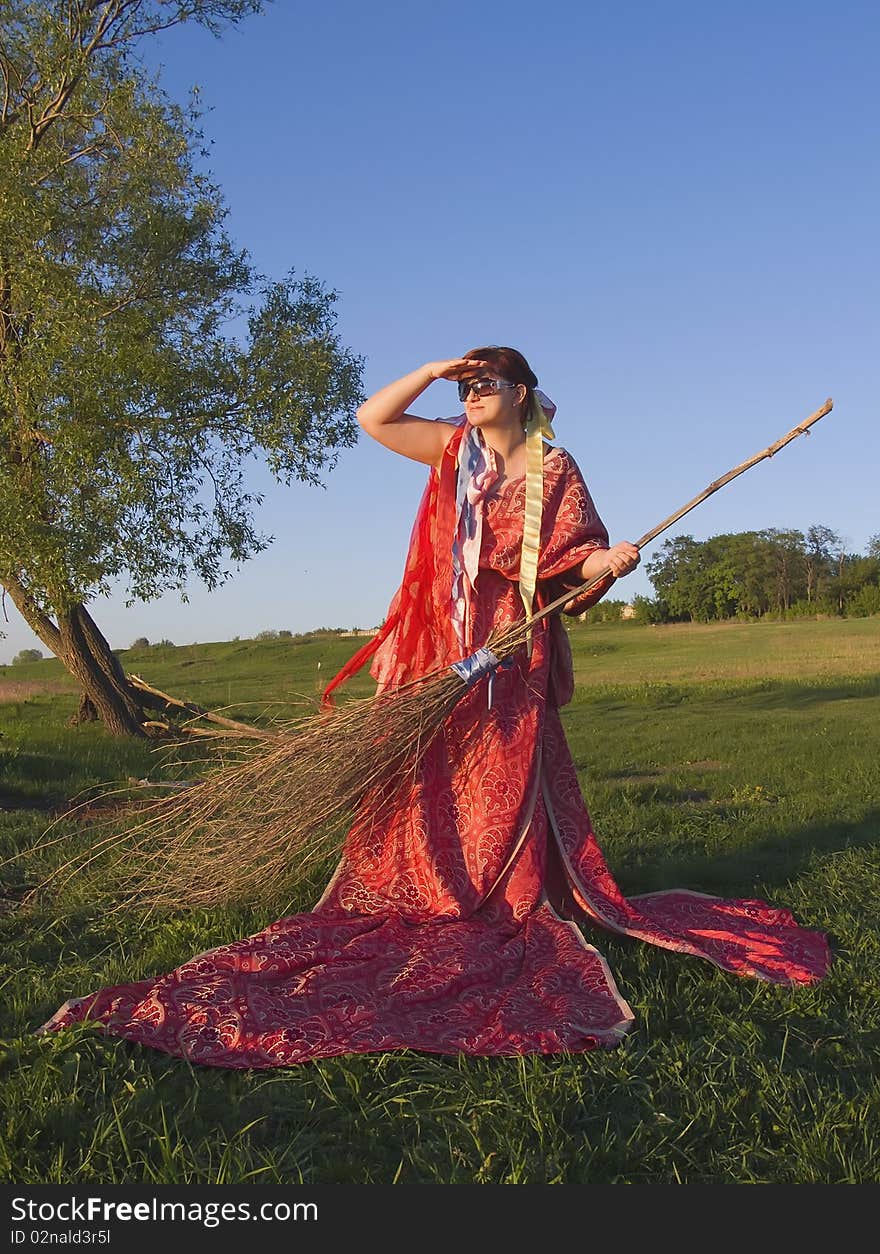 Witch in the open air holding a broom