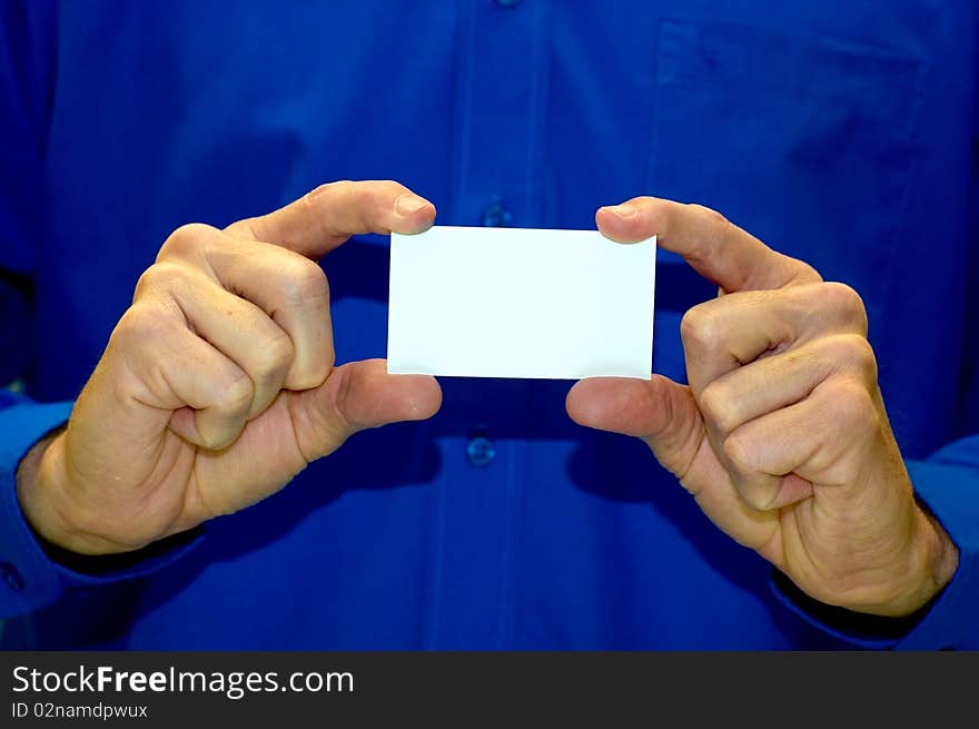 A man in a blue business shirt holding a blank business card. A man in a blue business shirt holding a blank business card