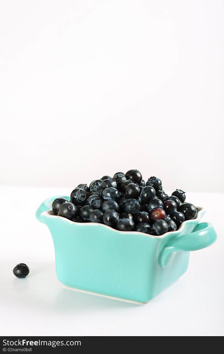 Fresh blueberries in blue bowl vertical