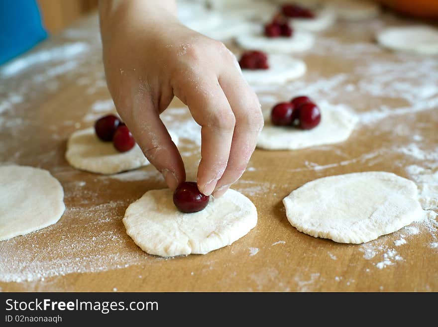 Hand cooking dumplings with fresh red cherries