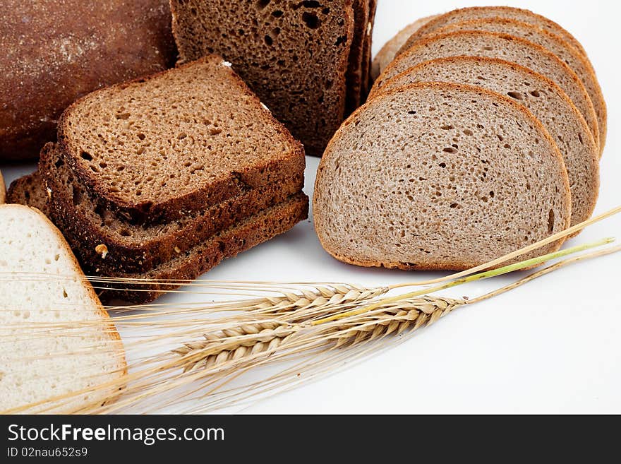 Various sorts of bread and spikes on white background