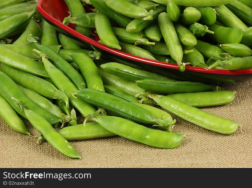 Delicious fresh green peas on red plate