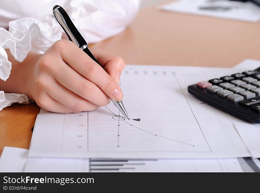 The hand of a young girl holding a black pen. Workplace business woman.