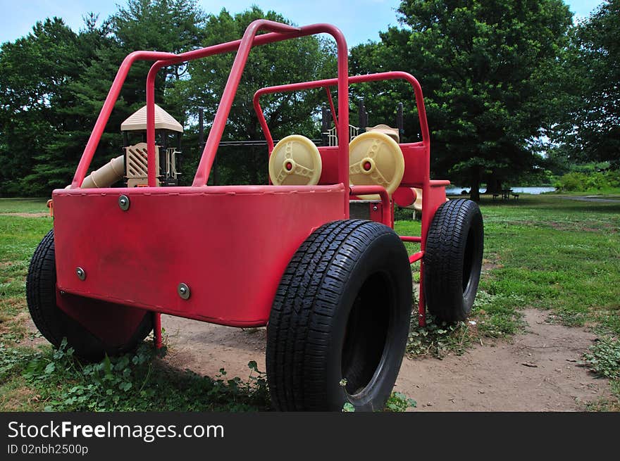 Rear and side of a playground machine resembling a Jeep made of welded metal tubes in a public park. Rear and side of a playground machine resembling a Jeep made of welded metal tubes in a public park.