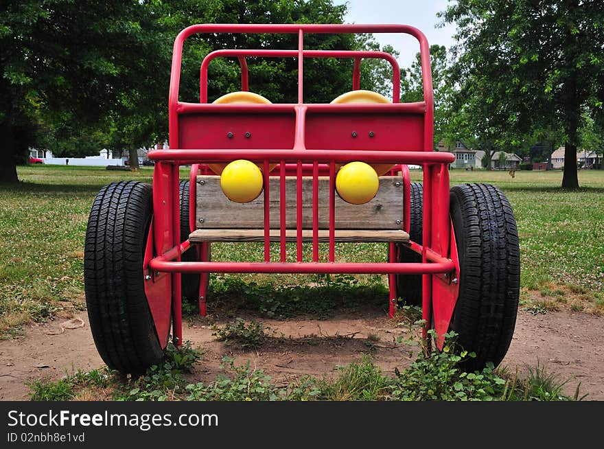 Front of a playground machine resembling a Jeep made of welded metal tubes in a public park. Front of a playground machine resembling a Jeep made of welded metal tubes in a public park.