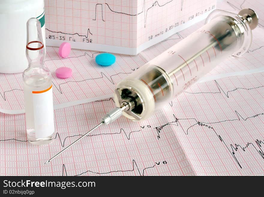 Old glass syringe and drug on the cardiogram tape