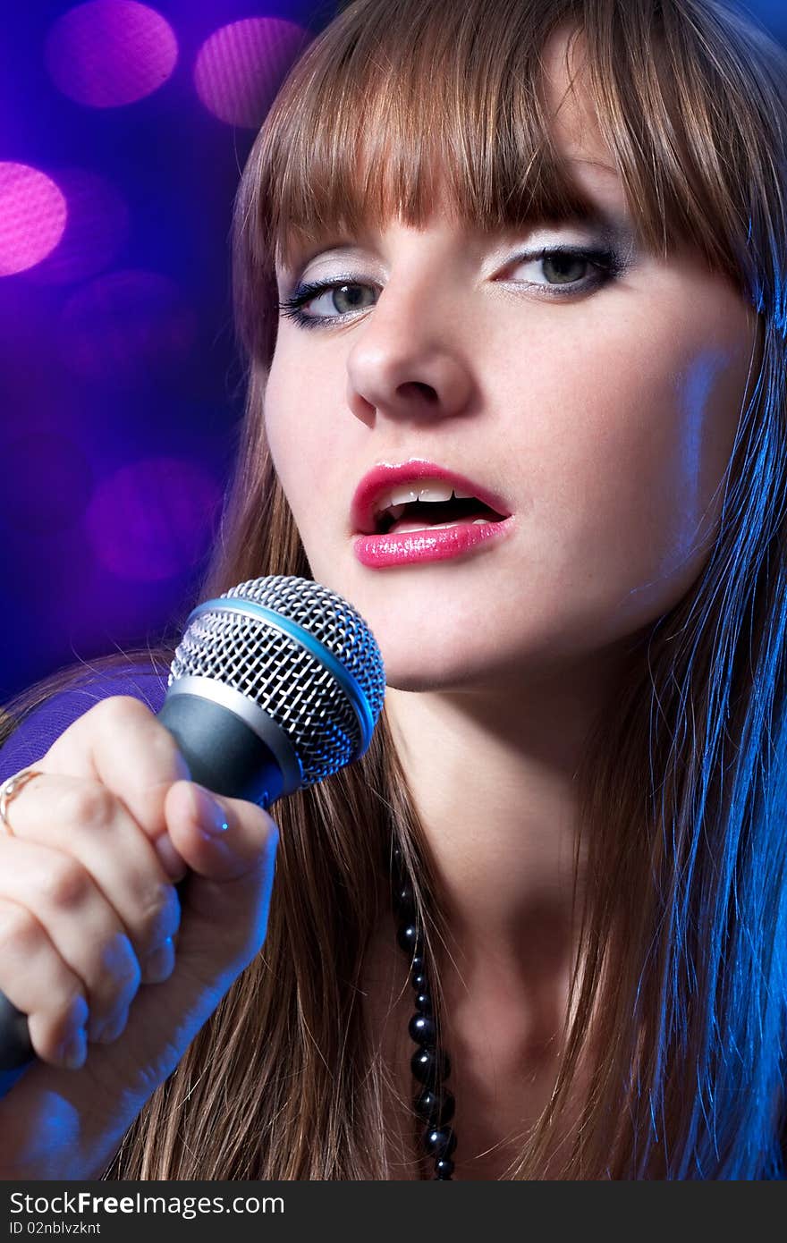 Portrait young Woman Singing into Microphone