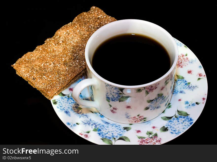 A cup of coffee and a bread crisp. A cup of coffee and a bread crisp