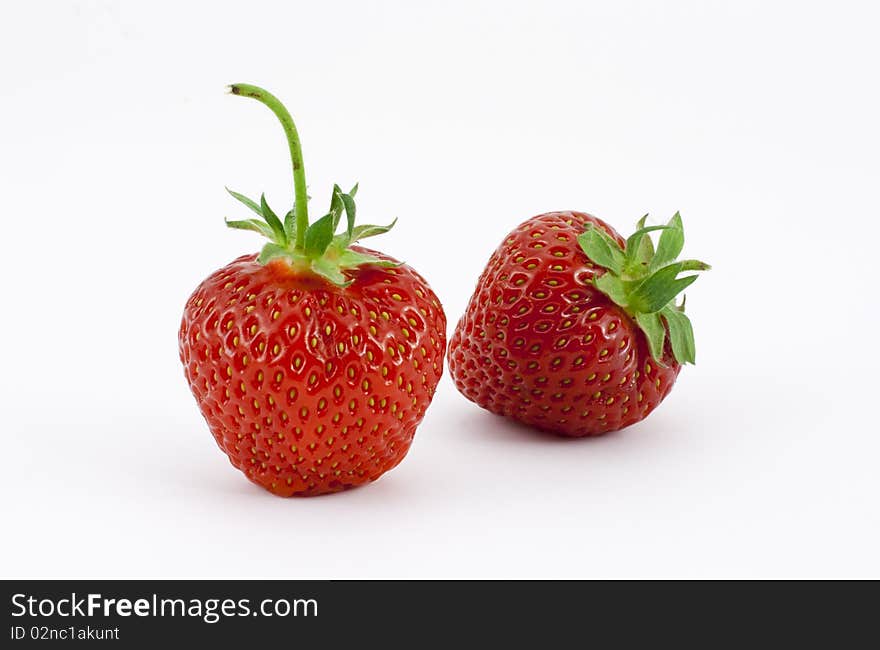 Two isolated strawberries on white. One upright the other at an angle. Two isolated strawberries on white. One upright the other at an angle.