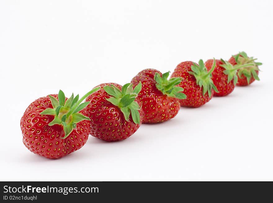 Six ripe, freshly picked strawberries in a row with narrow depth of field. Six ripe, freshly picked strawberries in a row with narrow depth of field.