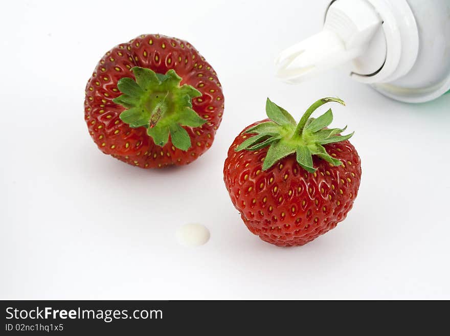 Two strawberries, a spot of cream and a dispenser. Two strawberries, a spot of cream and a dispenser