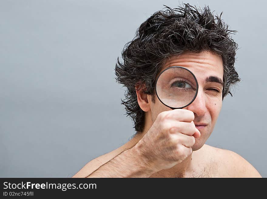 Curious man holding a magnifier over his eye. Curious man holding a magnifier over his eye