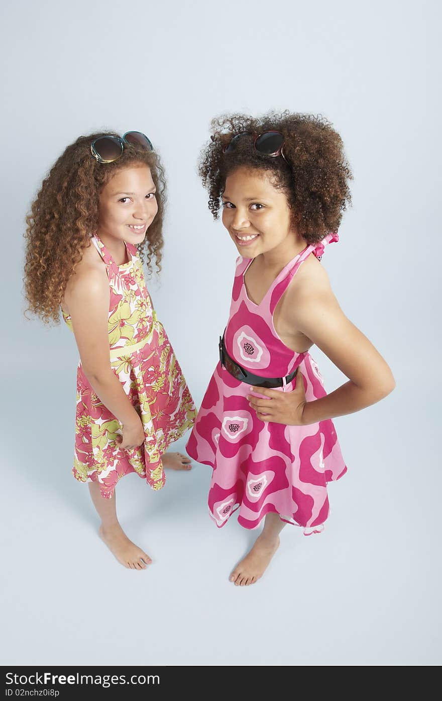 Two mixed race girls together in summer dresses. Two mixed race girls together in summer dresses