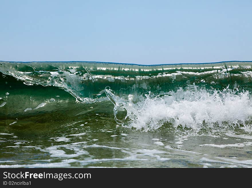 Green sea wave disperses the foam. Green sea wave disperses the foam