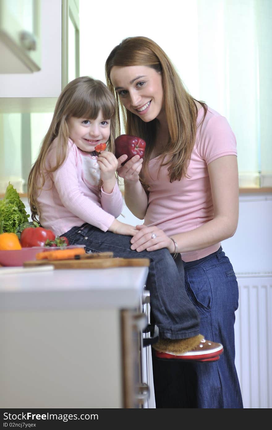 Happy young family have lunch time with fresh fruits and vegetable food in bright kitchen. Happy young family have lunch time with fresh fruits and vegetable food in bright kitchen