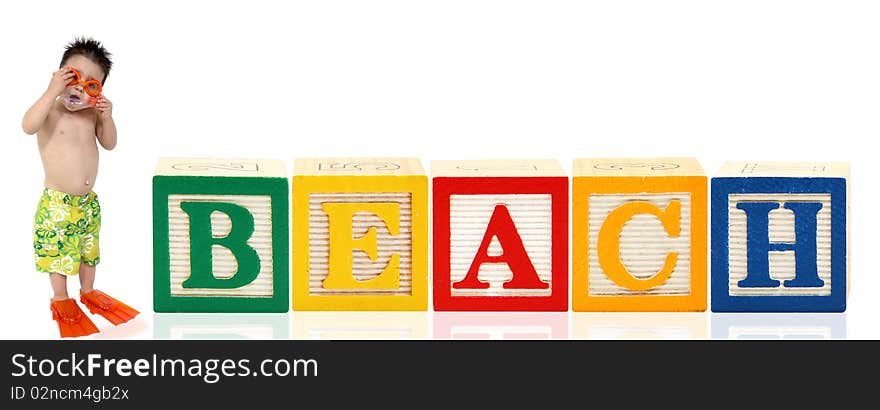 Colorful alphabet blocks. spelling the word beach. Adorable three year old boy in swimsuilt standing beside it. Colorful alphabet blocks. spelling the word beach. Adorable three year old boy in swimsuilt standing beside it.