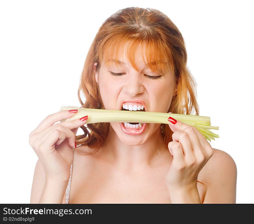 A redhead young woman biting a fresh green celery. A redhead young woman biting a fresh green celery