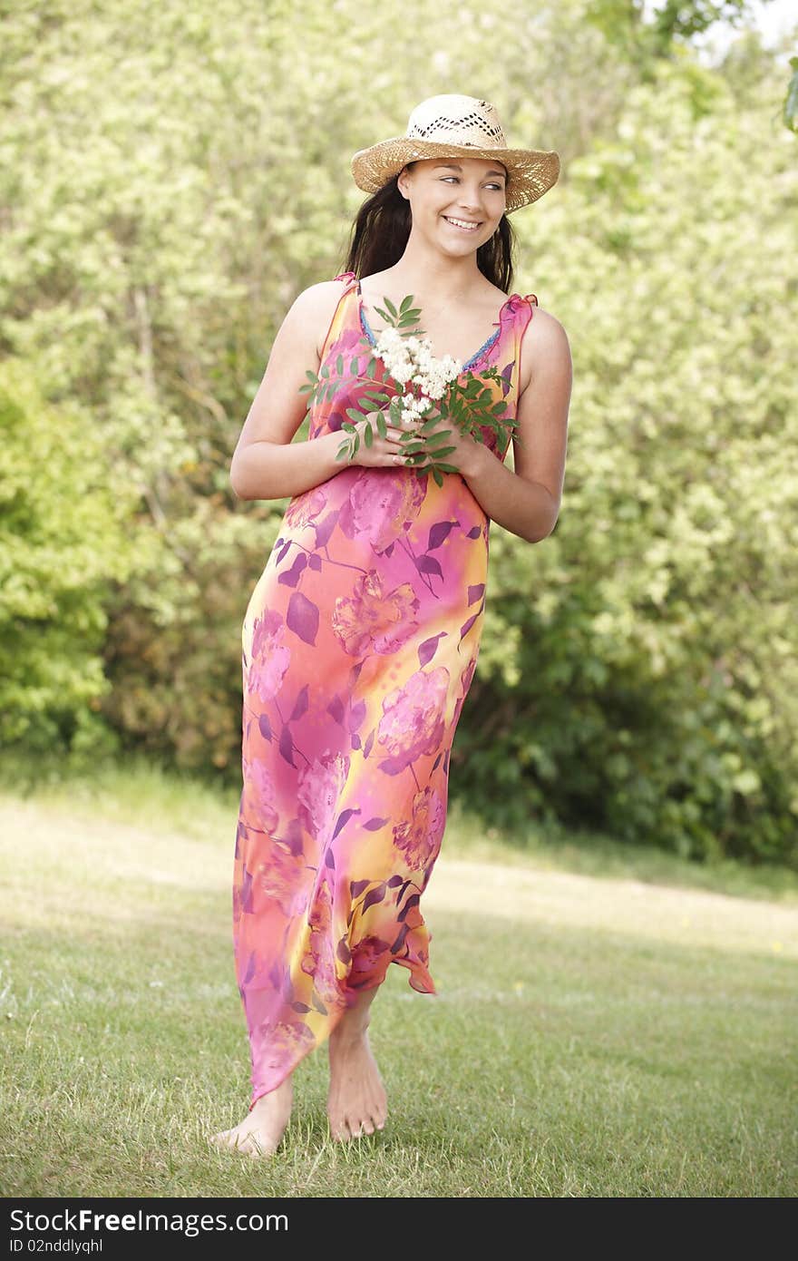 Young attractive woman smiling while walking towards camera in a field. Young attractive woman smiling while walking towards camera in a field