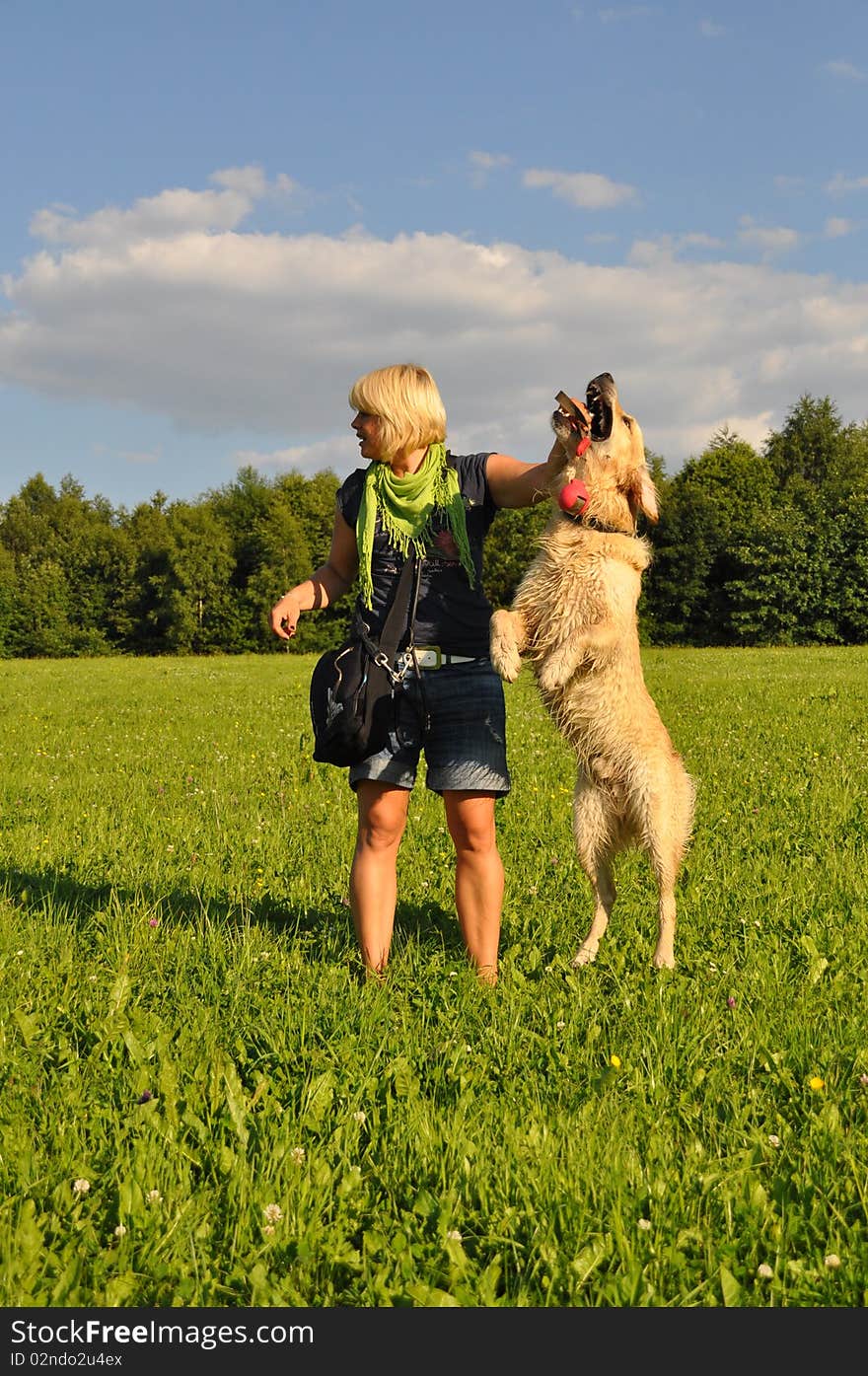 Happy young woman playing with her golden retriever. Happy young woman playing with her golden retriever