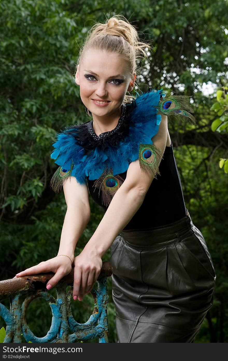 Portrait of girl in blouse with peacock feathers