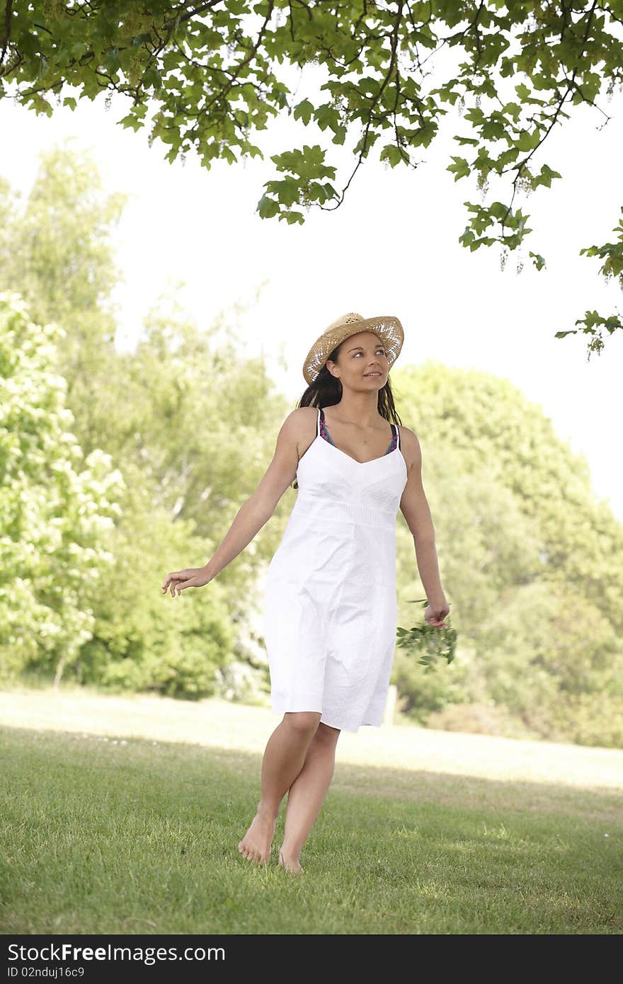 Young attractive woman smiling while walking towards camera in a field. Young attractive woman smiling while walking towards camera in a field