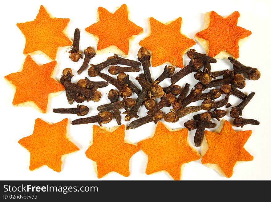 Christmas spices - star shaped orange peel and cloves over white. Christmas spices - star shaped orange peel and cloves over white