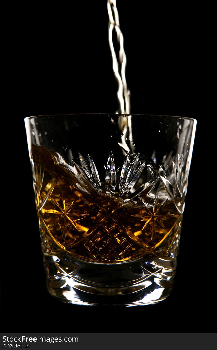 Whiskey being poured in crystal glass