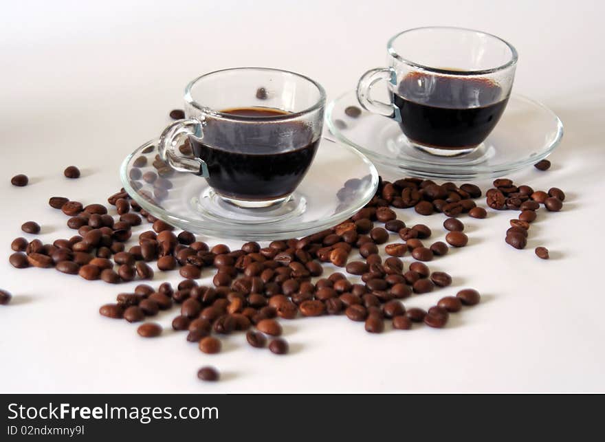 Two coffee cups and coffee beans on white background, still-life. Two coffee cups and coffee beans on white background, still-life