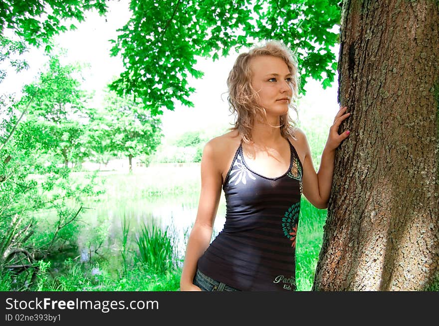 Young girl based on the park tree. Young girl based on the park tree.