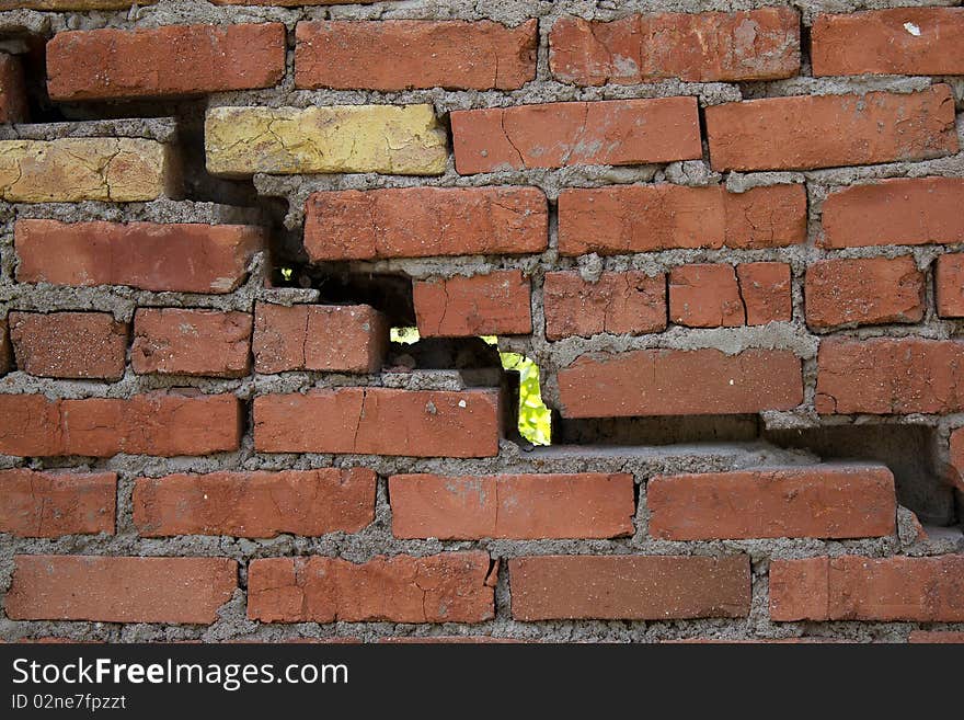 The big crack and hole in a wall a construction from a brick. The big crack and hole in a wall a construction from a brick