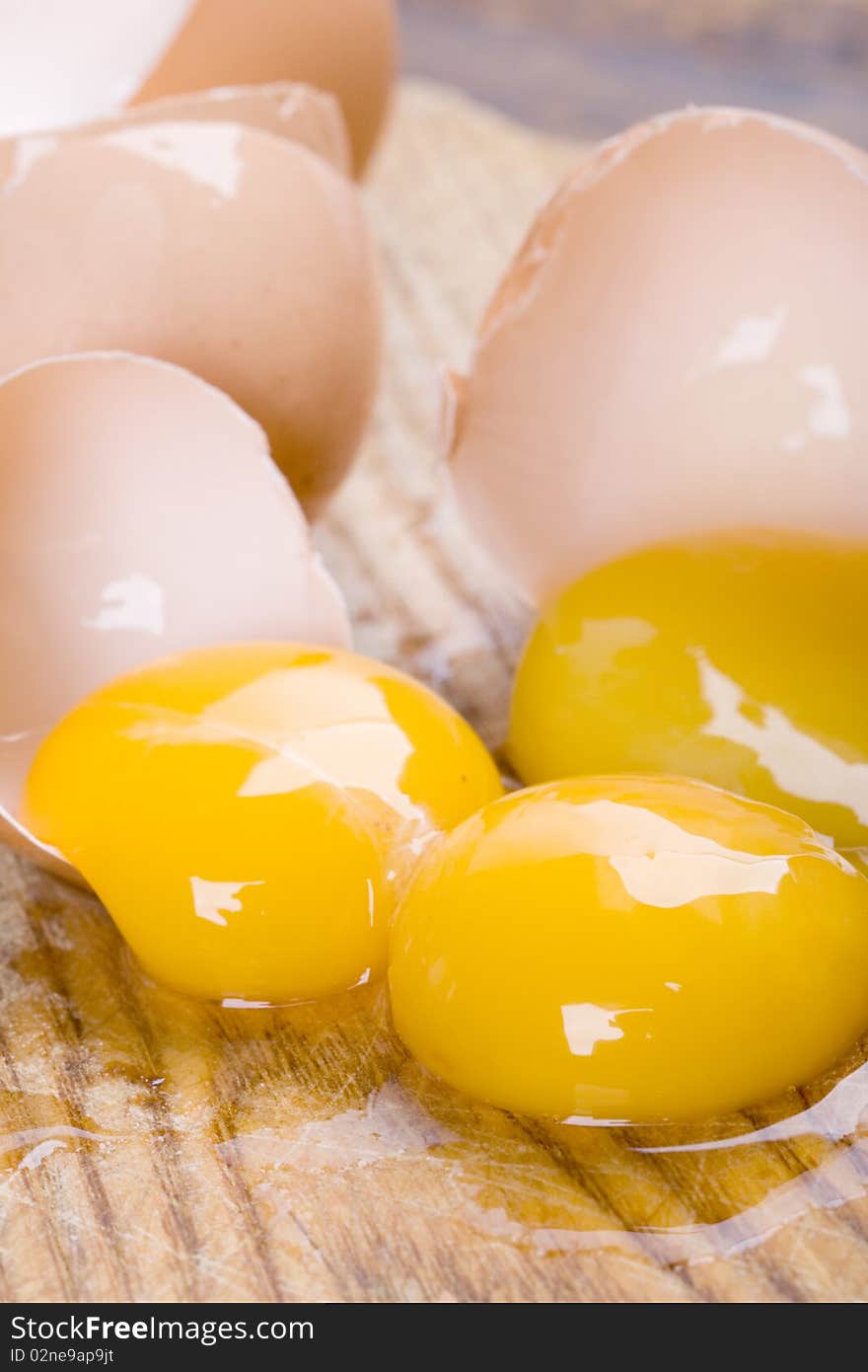 Broken brown eggs closeup on wooden background