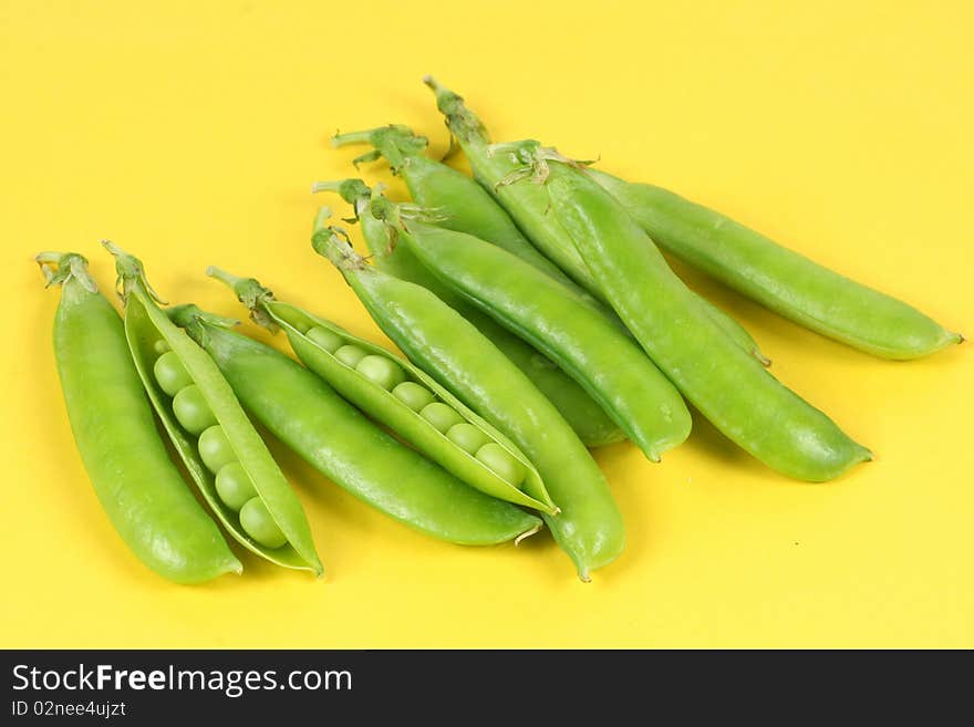 Green peas isolated on the Yellow background