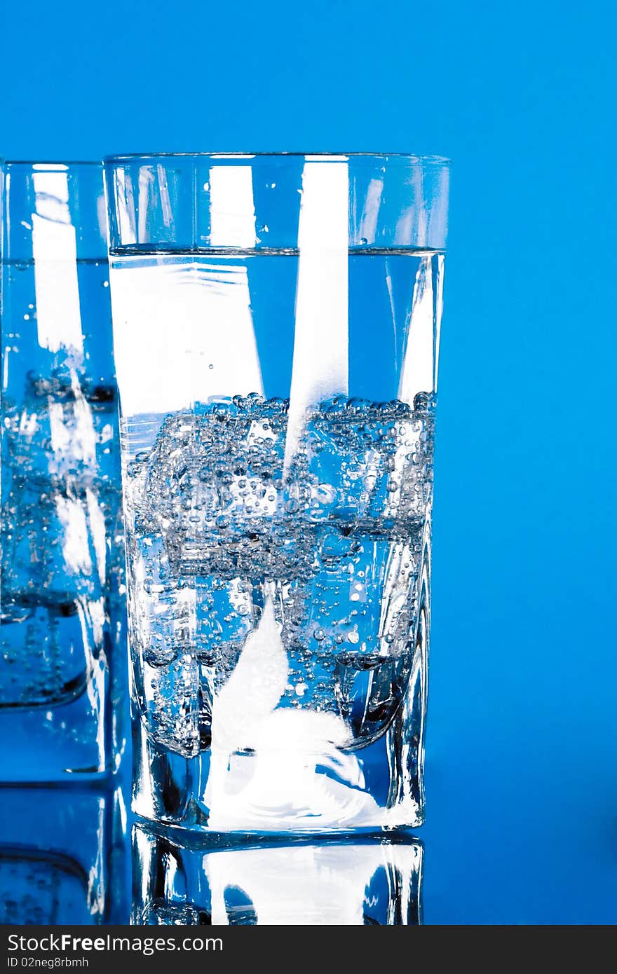 Glasses with cold water on blue background