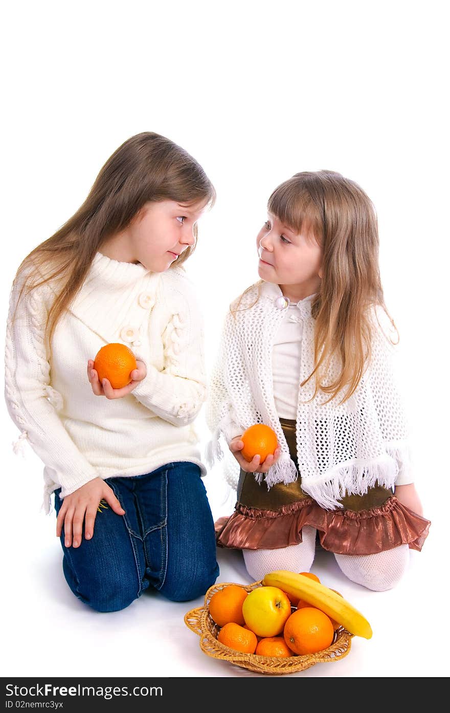 Two little girls with fruit on white