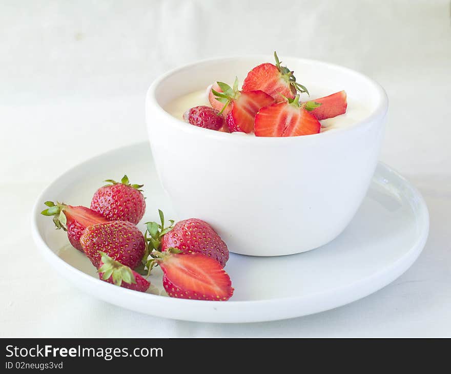 Yogurt with strawberries for breakfast in white bowl