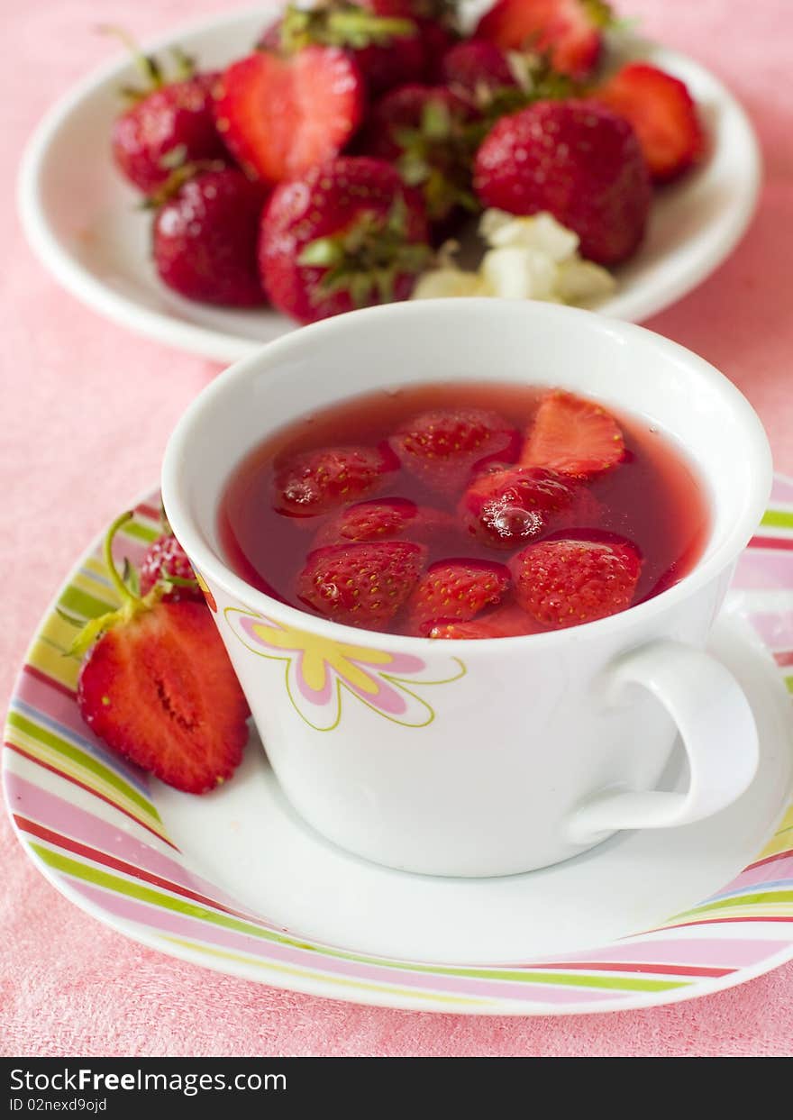 Strawberry tea in a white mug with fresh strawberry. Strawberry tea in a white mug with fresh strawberry