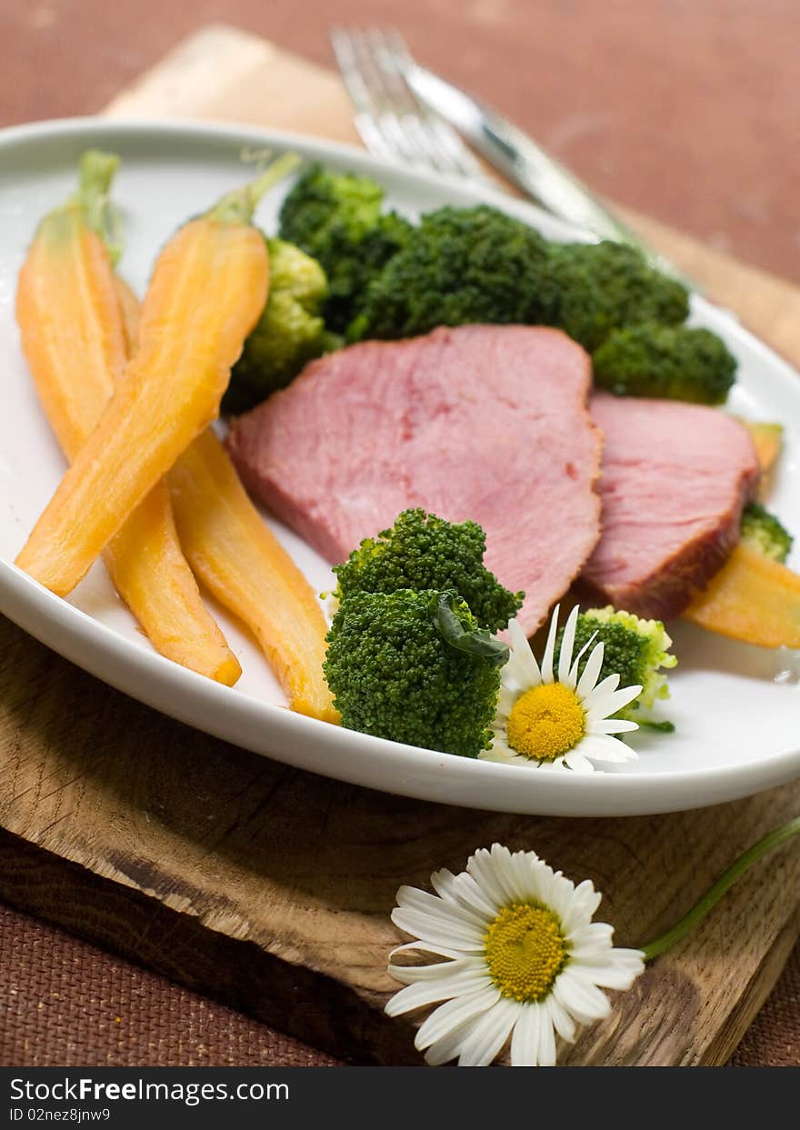 Boiled carrots and a broccoli with stewed meat for a dinner