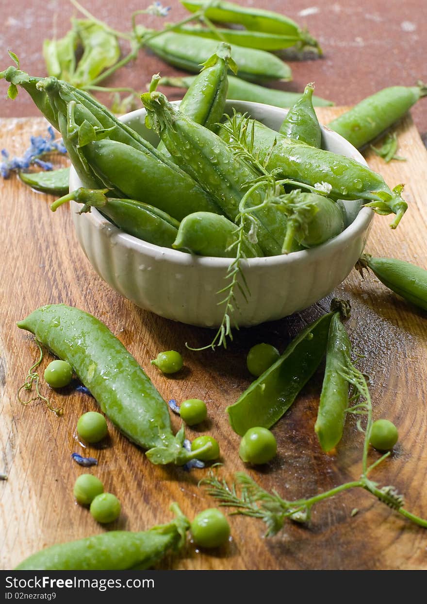 Freshly picked sweet garden peas in a bowl sitting on a table. Freshly picked sweet garden peas in a bowl sitting on a table