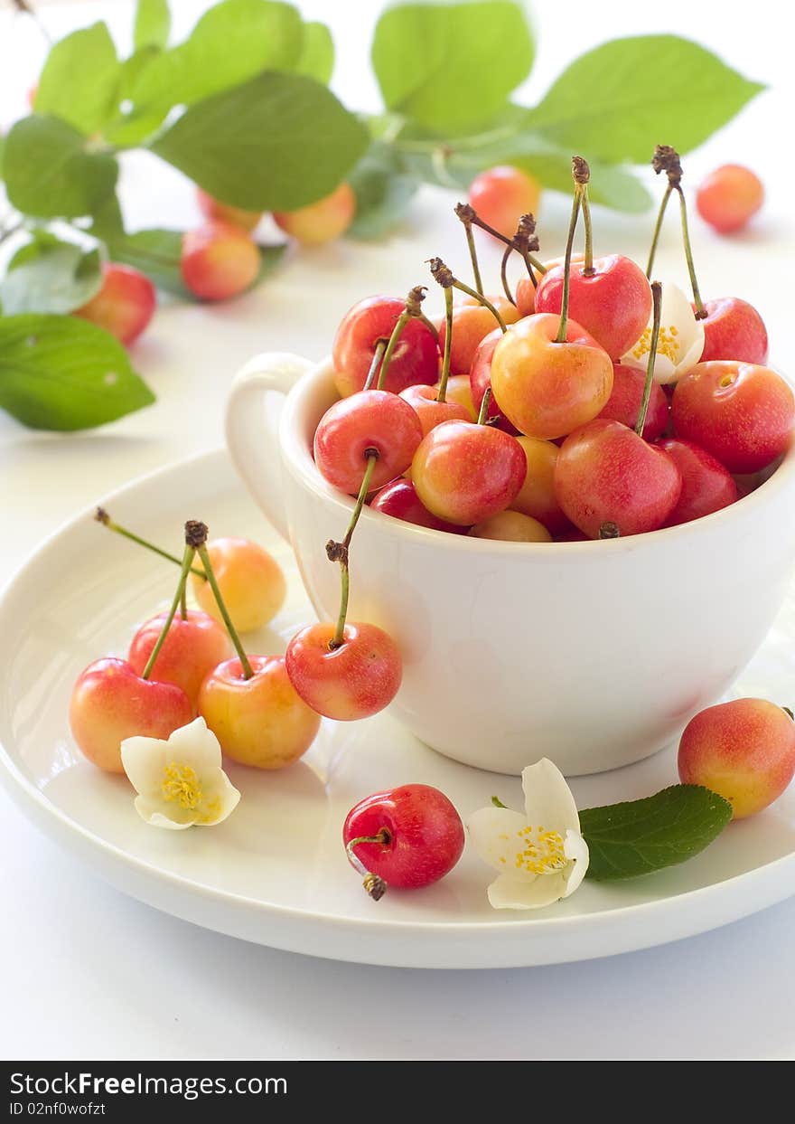 A cup of cherry with flower on light background