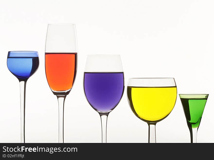 Five multi-coloured wine-glasses on white background